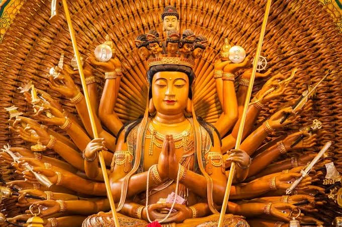 Worshippers lighting incense before altars in a busy Chinese temple courtyard